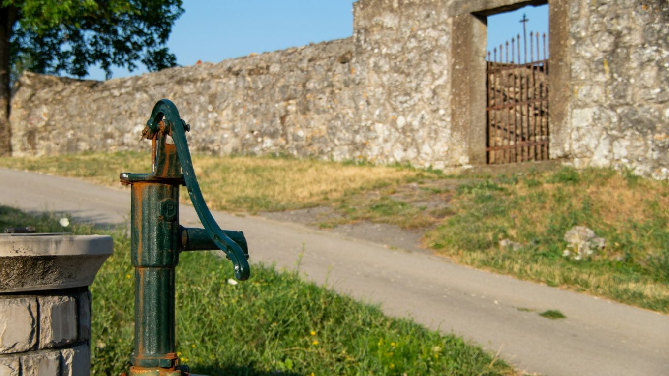 a green fire hydrant sitting on the side of a road