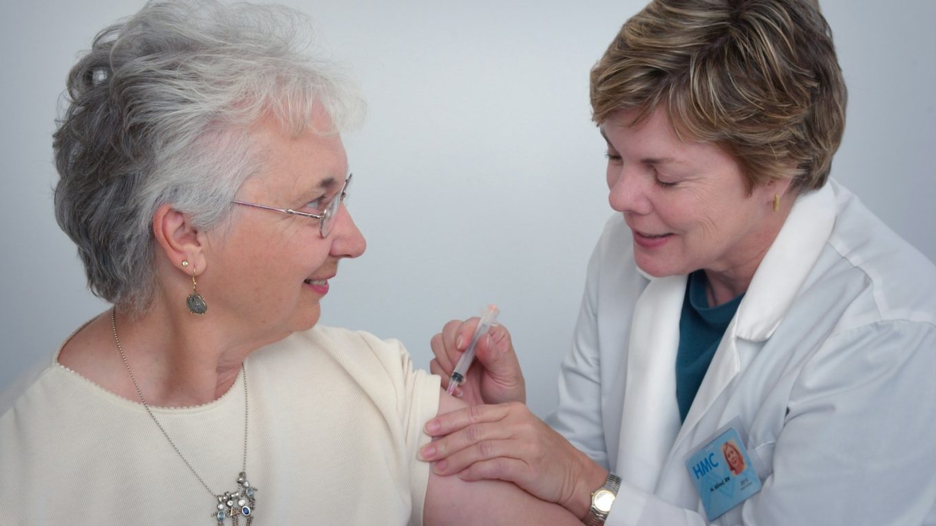 woman inject a woman on left shoulder